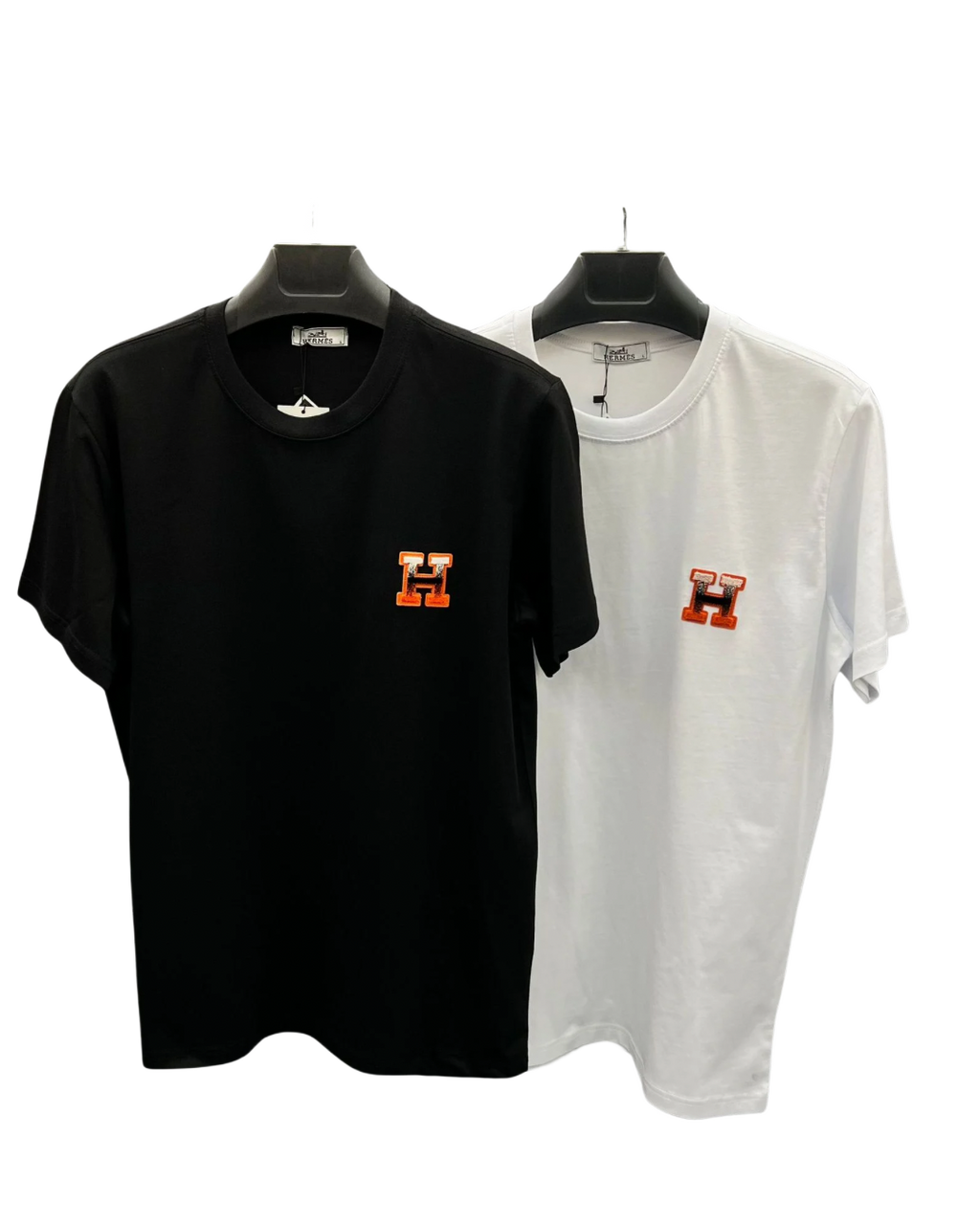 Black and white H logo T-shirts on hangers